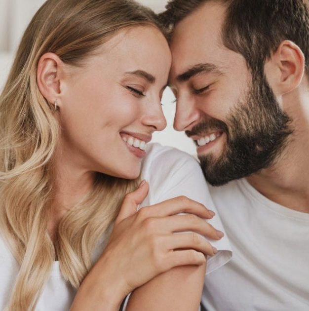 Young couple using the laptop in the bed at home