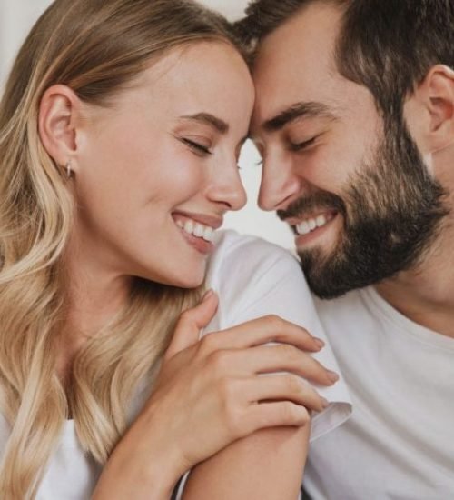 Young couple using the laptop in the bed at home